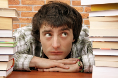 Student looking at stacks of books